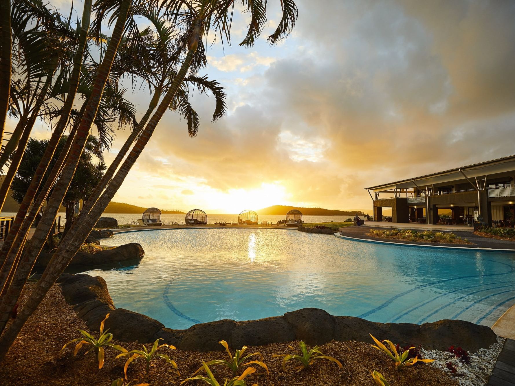 View of pool and trees during sunset at Daydream Island Resort