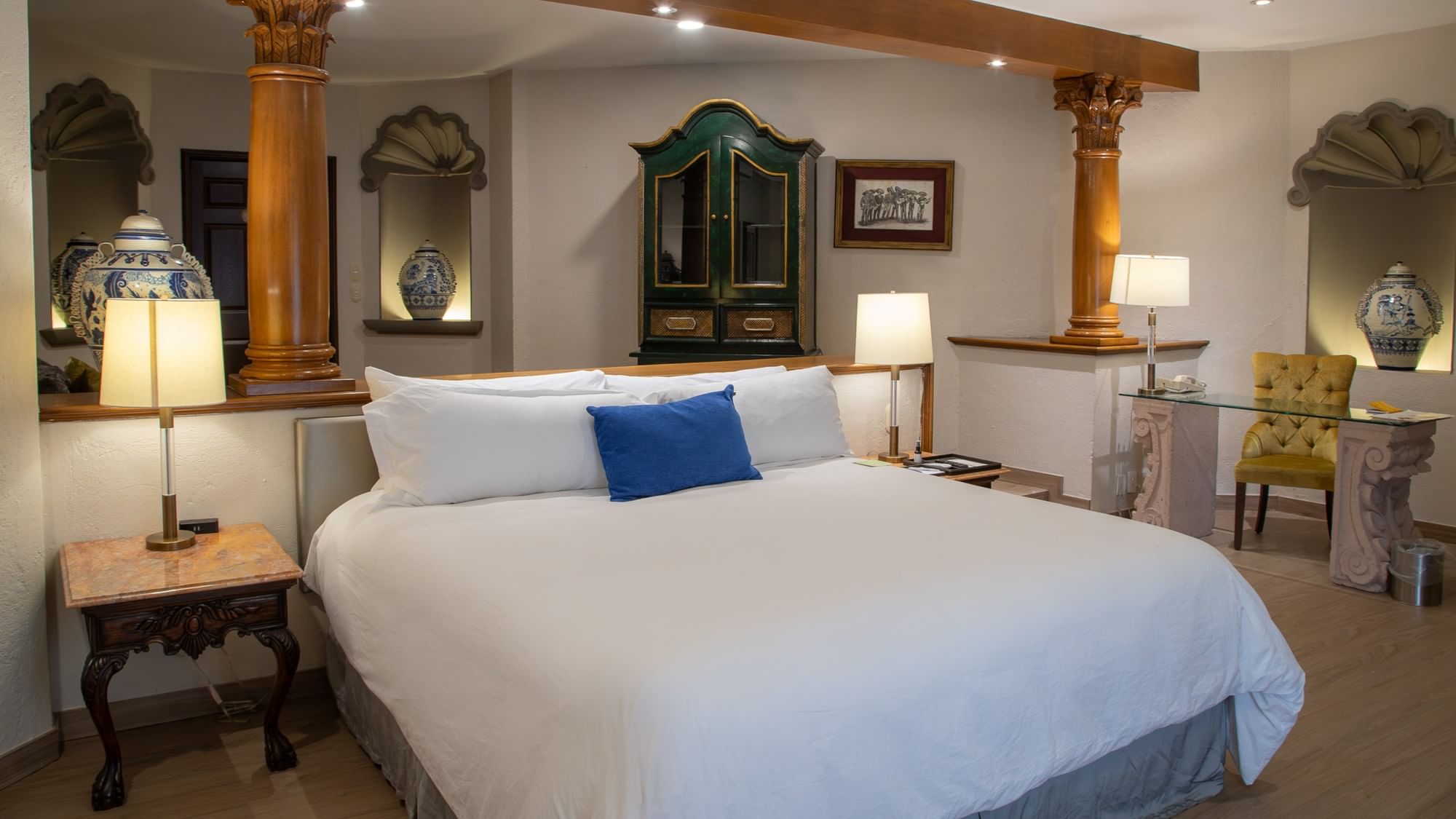 Suite Gran Clase King con cama king, columnas decorativas y armario verde en Quinta Real Guadalajara