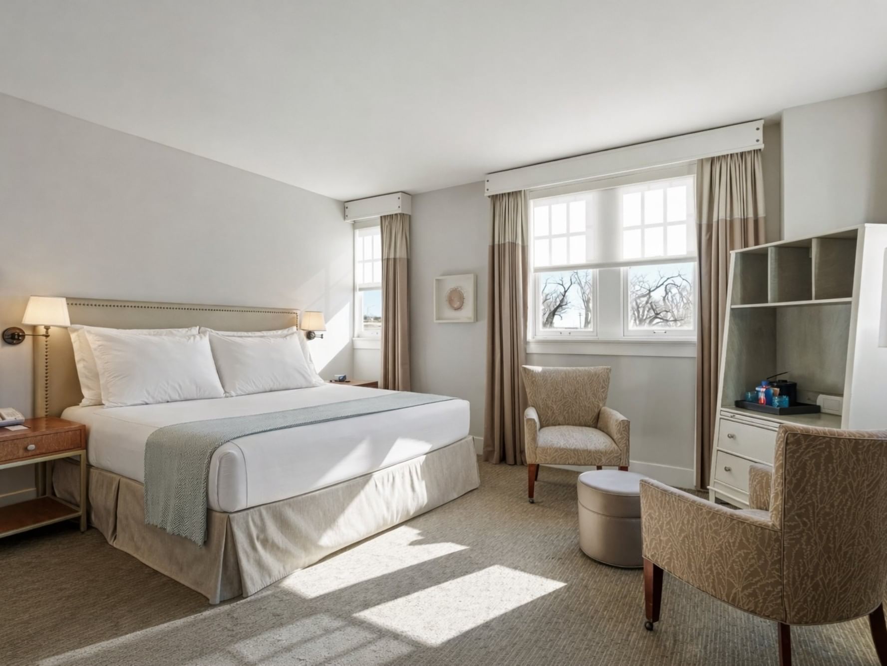 Deluxe King Room at Hotel Parq Central in Albuquerque with bed, chairs, and windows.