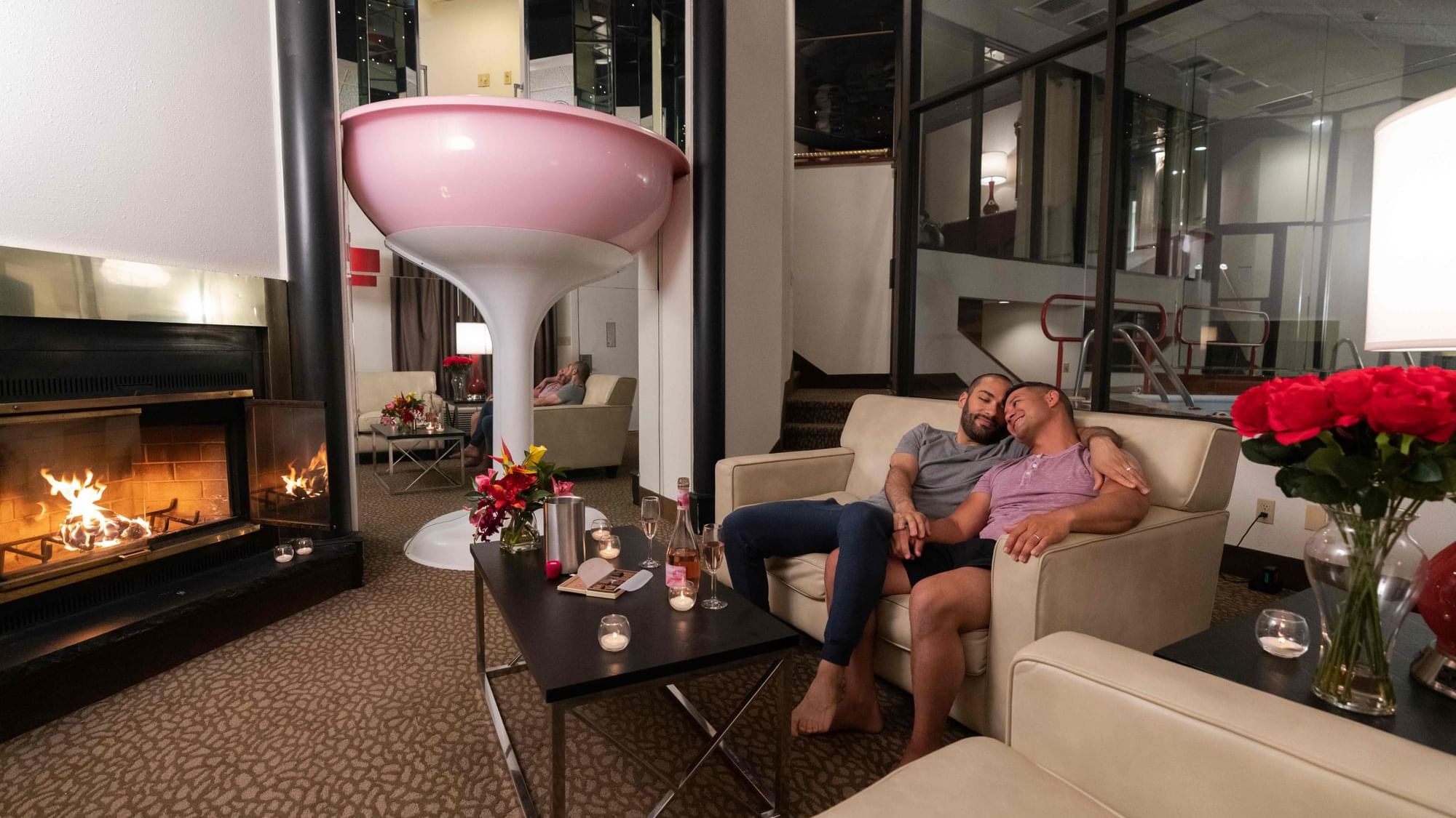 Couple enjoying champagne and sweet treats by the Champagne Tower fireplace at Cove Pocono Resorts