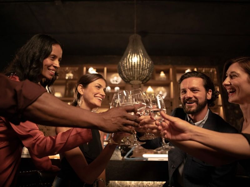 A group of people raises their glasses in a toast in Spice Market at Live Aqua San Miguel de Allende