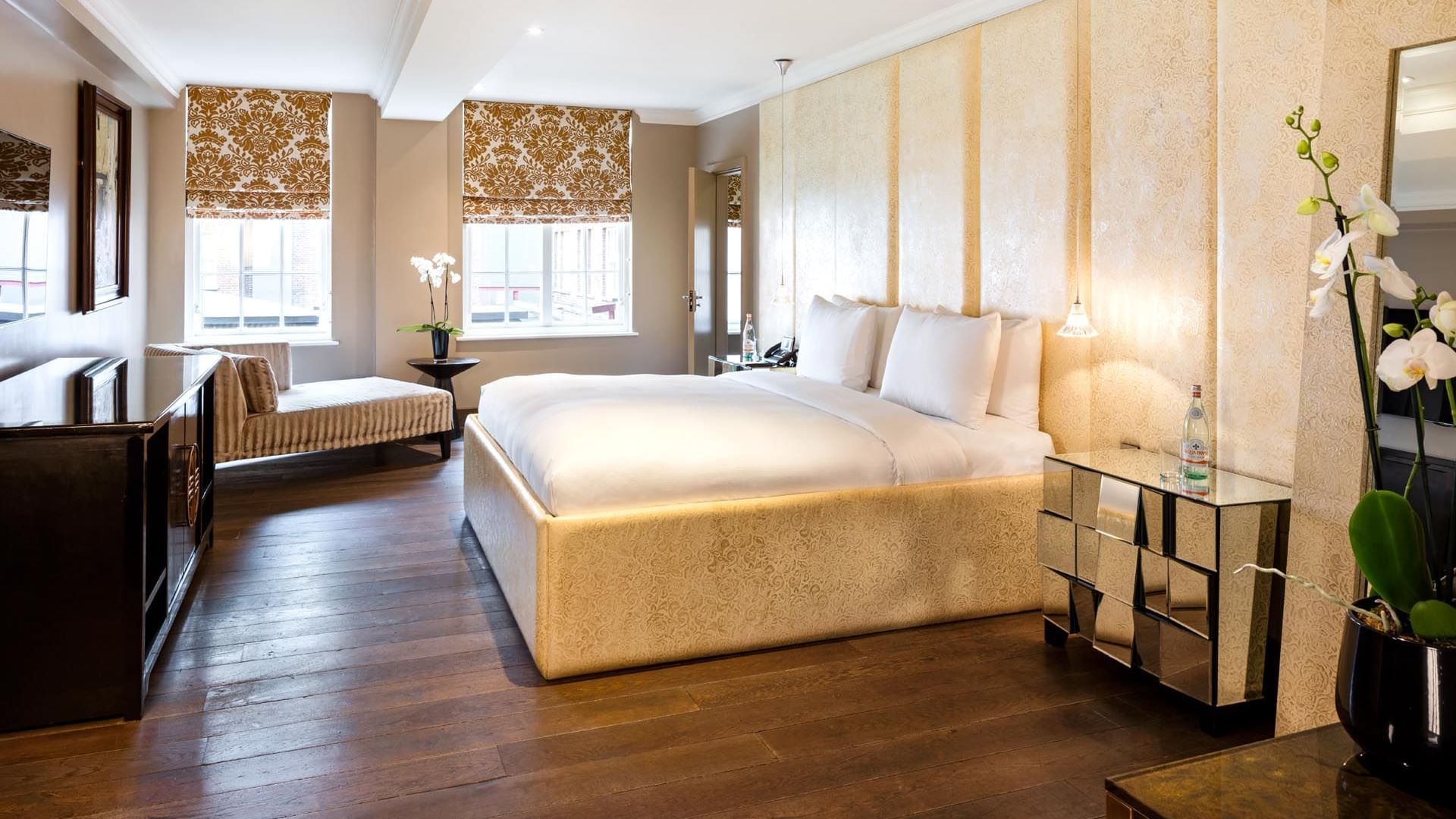 Luxurious hotel room in The Amber Suite at The May Fair Hotel London with a large bed and nightstand