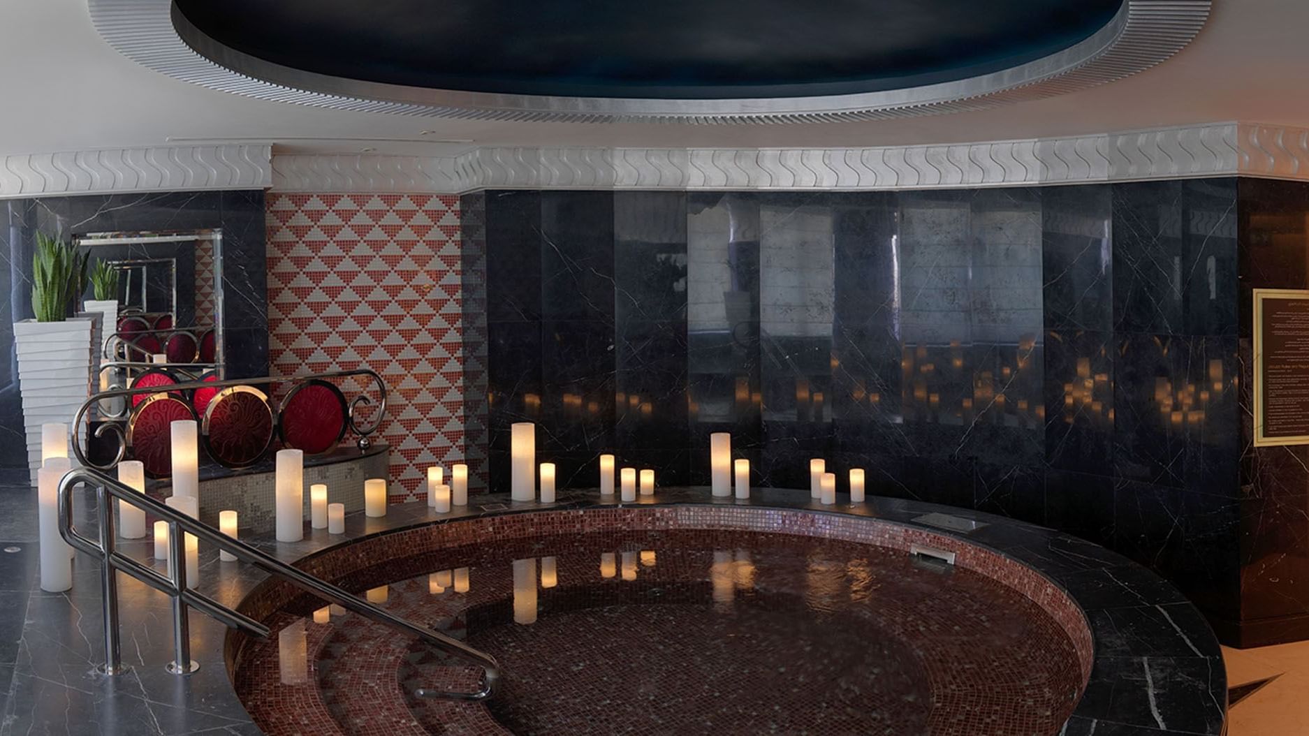 A luxurious bathtub adorned with candles in spa at DAMAC Maison Dubai Mall Street
