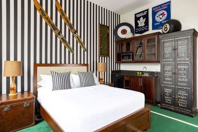 Queen bed, nightstand & striped side cupboard with pantry in Queen Premiere at Retro Suites Hotel