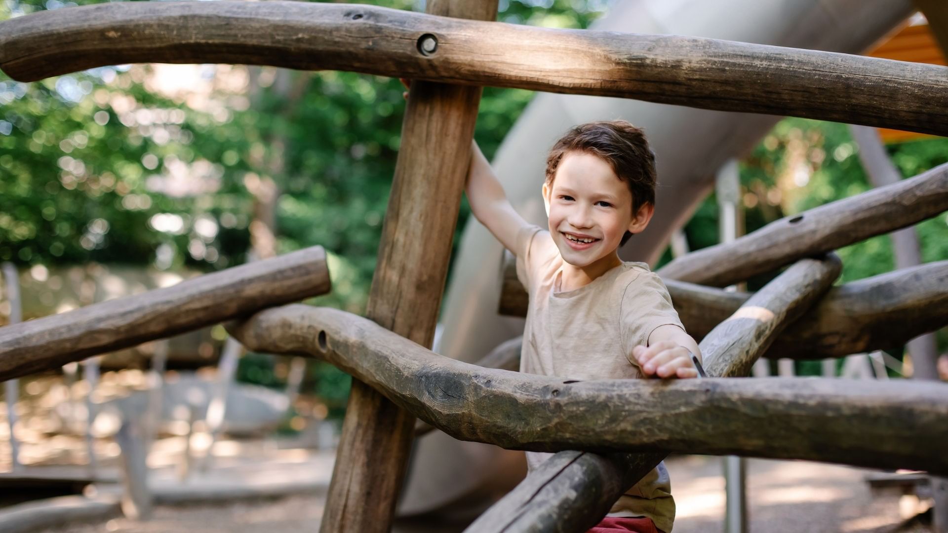 Smiling young boy playing on a wooden climbing structure inParque Ecológico Chipinque near Quinta Real Monterrey