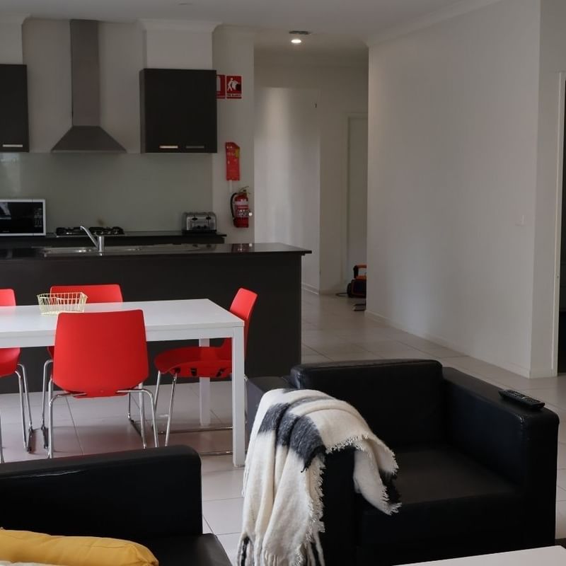 Modern living room with dining area and kitchen at La Trobe University Regional Housing.