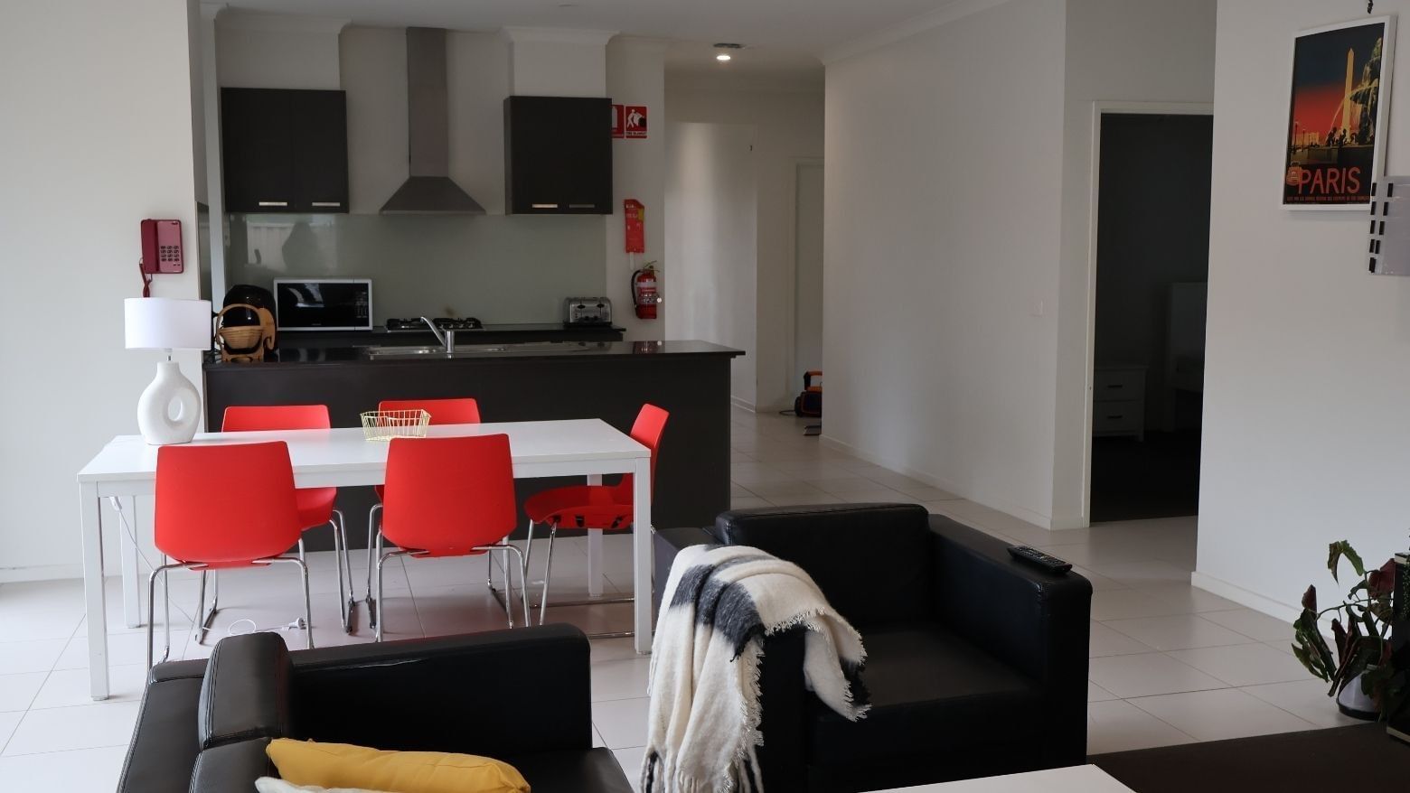 Modern living room with dining area and kitchen at La Trobe University Regional Housing.