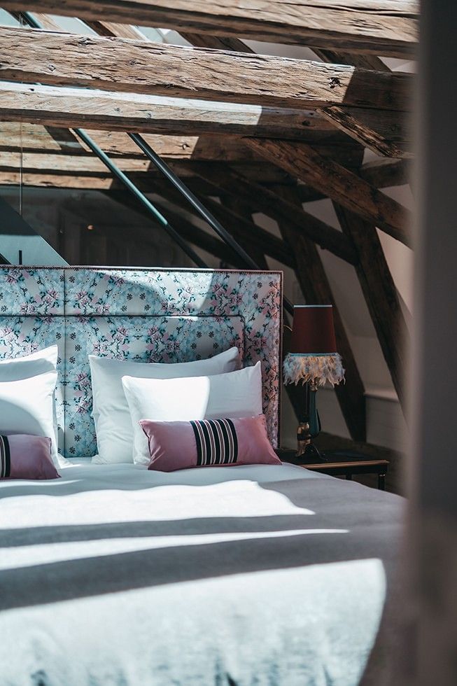 The oversized custom headboard of THE LEO GRAND guestrooms featuring the Carrier Pigeon fabric inspired by Les Colombes woven for Catherine the Great in Versailles and produced in Austria's Waldviertel