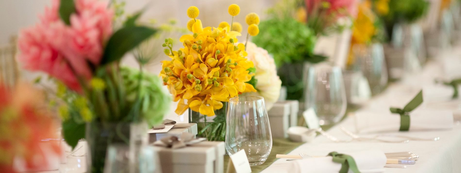 Close-up of table arranged for an event with flowers and glasses at The Fullerton Hotels and Resorts