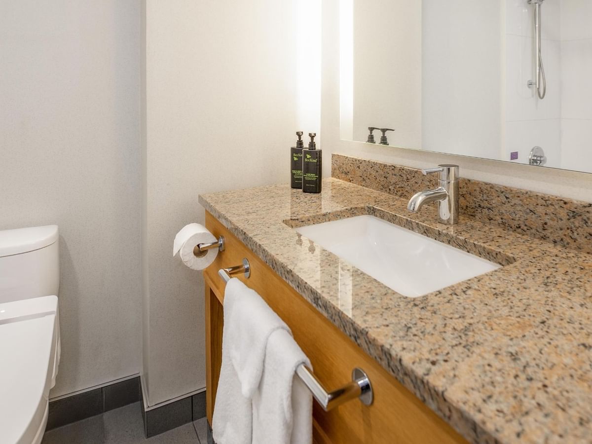 Bathroom with toilet, sink, and towel.