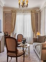 TV lounge with plush sofa near window in Deluxe Suite Belle Époque at Hotel Westminster Paris