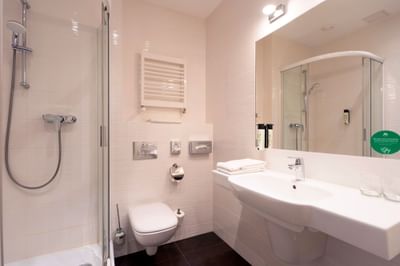 Bathroom with shower area, vanity, toilet, and towels in Executive Room at Metropol Hotel