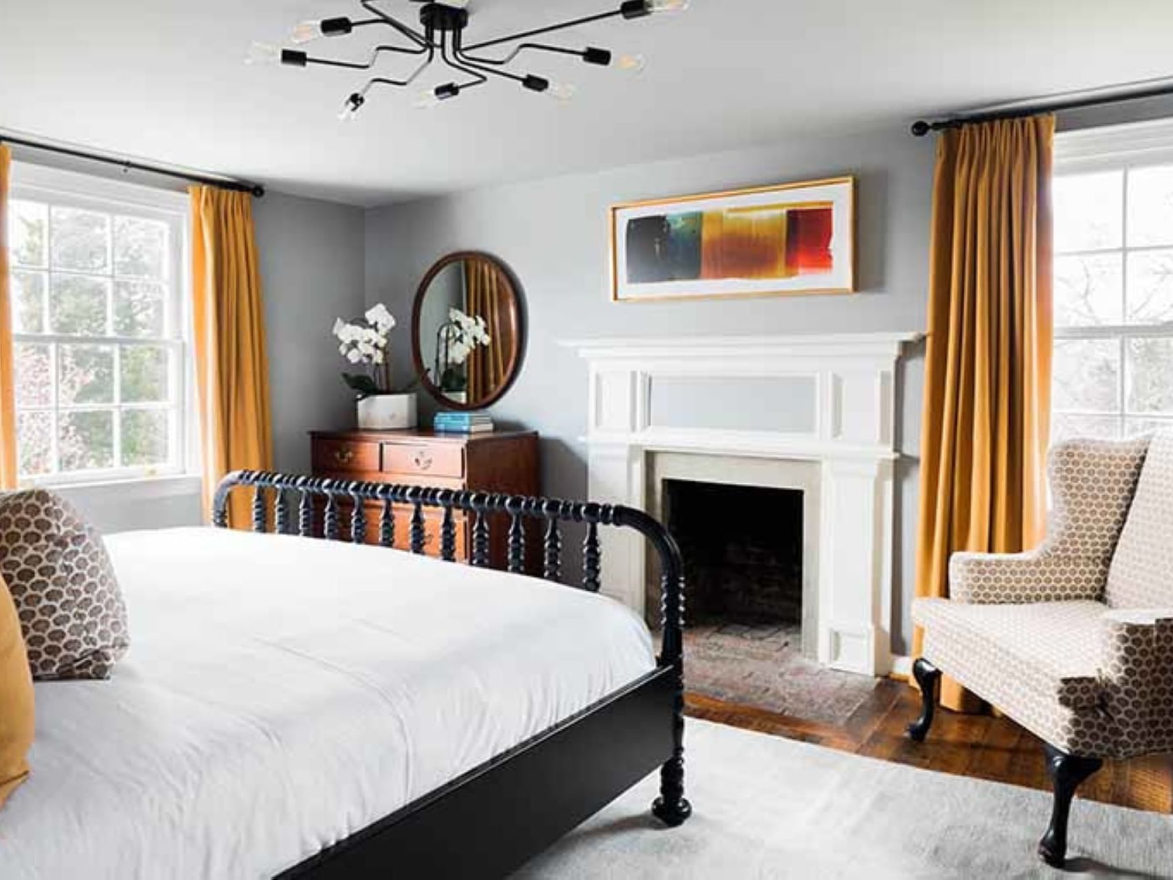 Cozy bed, fireplace, lounger & dressing table with mirror in Monticello Suite at The Clifton