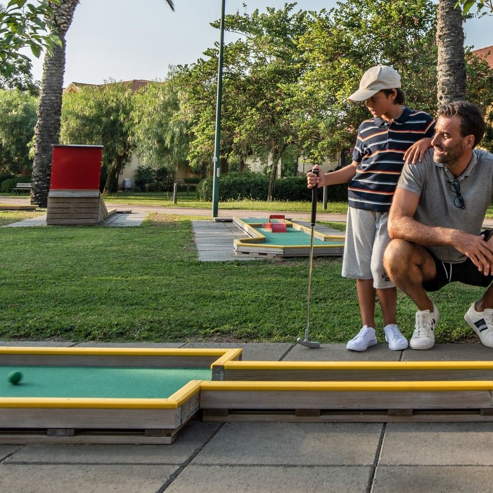 Man and boy playing mini golf together at Falkensteiner Family Resort Sicily