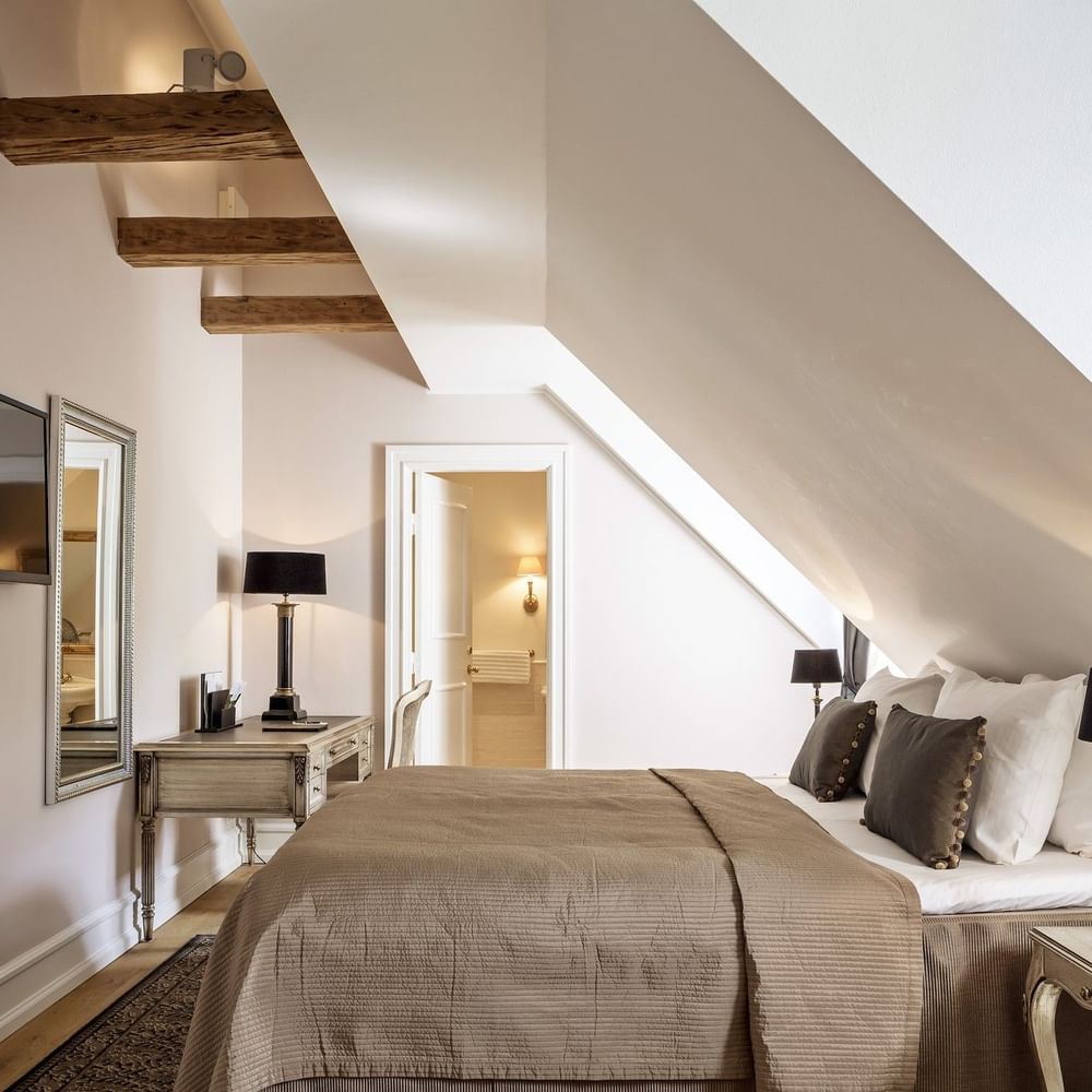 Executive room featuring large comfy bed facing wall mounted TV beside mirror with work desk at Warwick Denmark