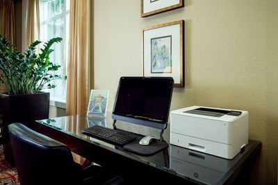 Work area with monitor and printer in Business center of Plaza Inn & Suites at Ashland Creek​