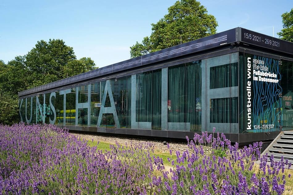 Modern glass façade of Kunsthalle Wien in MuseumsQuartier with blooming lavender field in the foreground