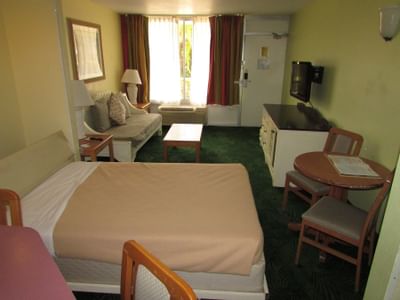 Hotel room with bed, couch, TV and table