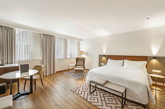 King bed, dining table & wooden floors in a Room at Federal Hotels International