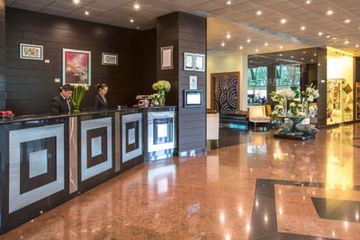 Pleasant two receptionists in the elegant lobby with beautiful interiors at Hotel Los Delfines & Casino