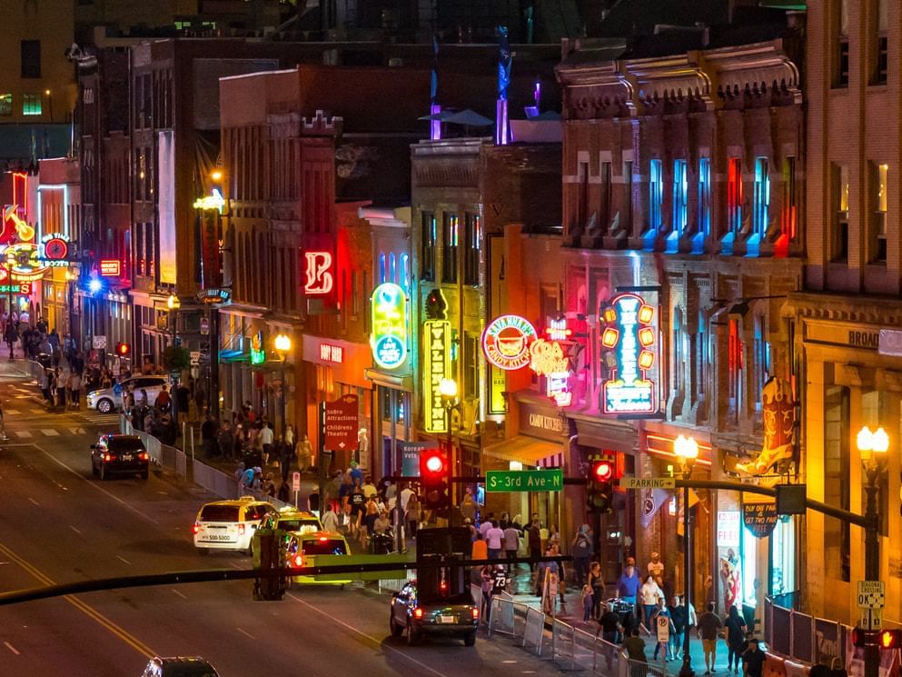 A vibrant city street at night near Hayes Street Hotel