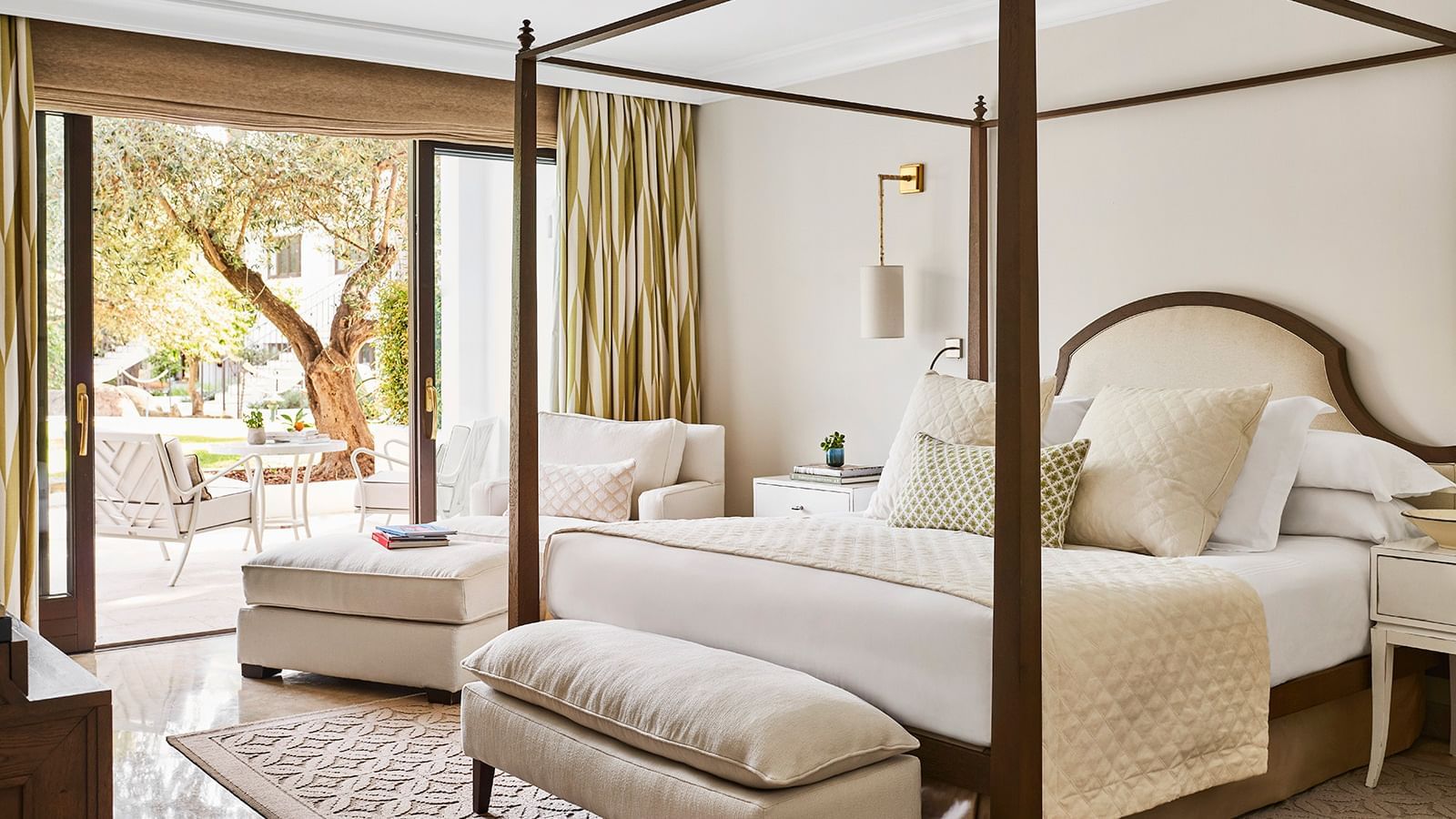 Bedroom with a four-poster bed near a chaise lounge, overlooking a garden patio at Marbella Club