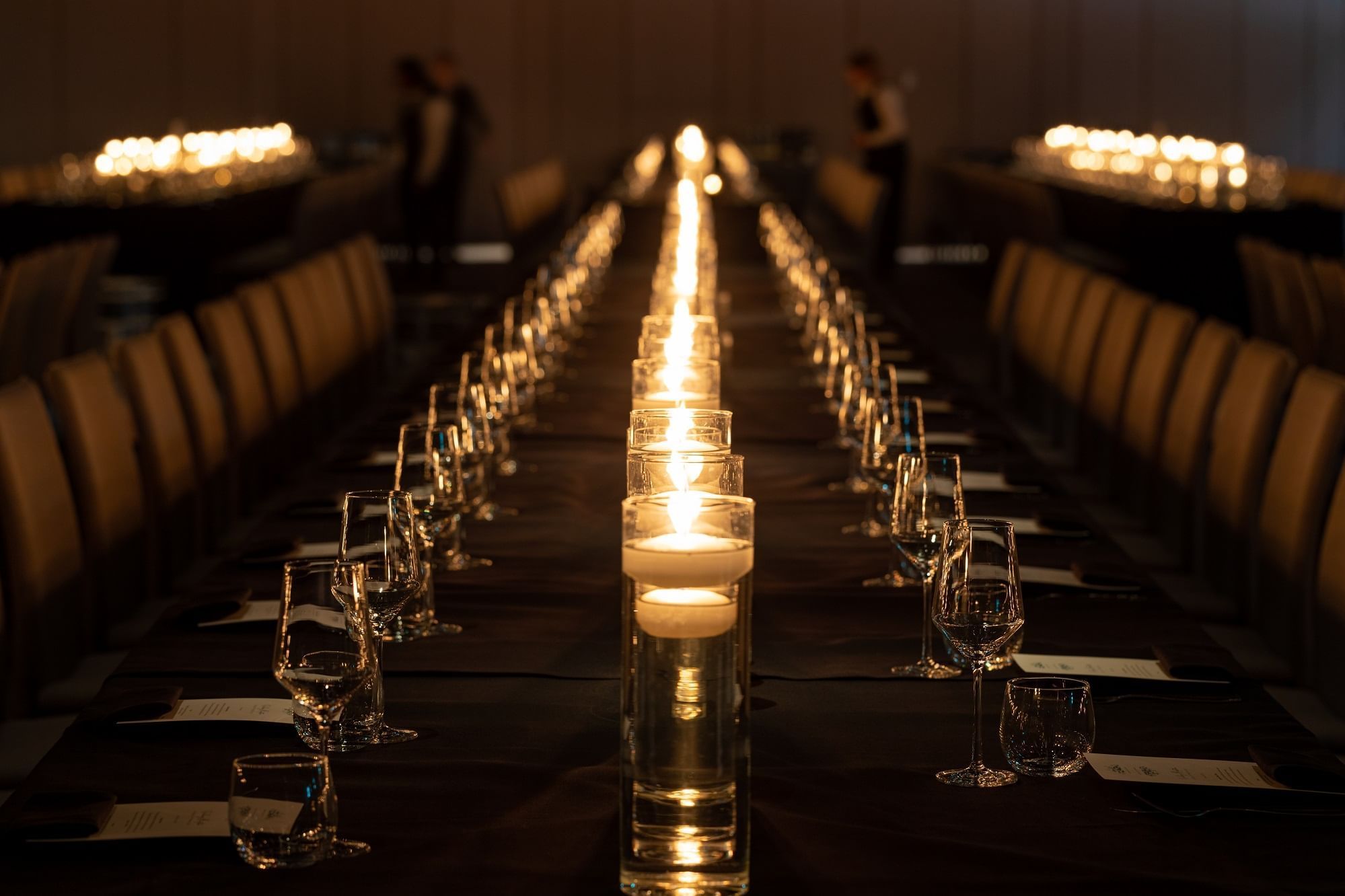 Close-up of a dining table arrangement with candles and glasses at The Londoner Hotel