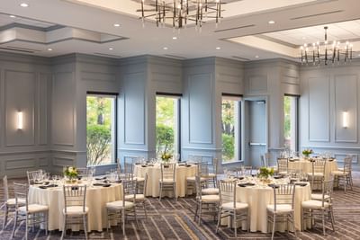 Elegant round dining tables with Chiavari chairs in the Grand Ballroom at Sable Oaks Weddings and Events