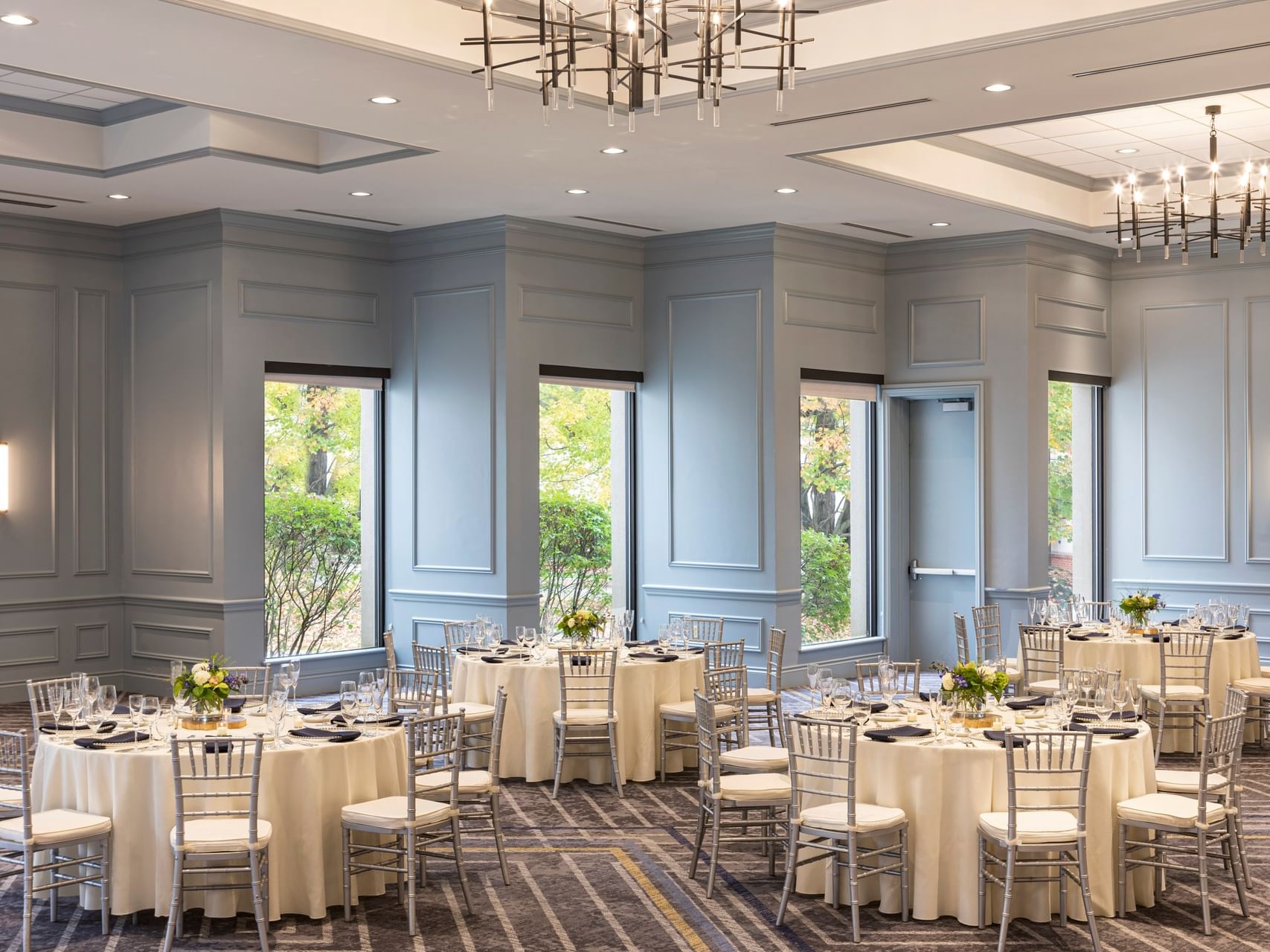 Elegant round dining tables with Chiavari chairs in the Grand Ballroom at Sable Oaks Weddings and Events