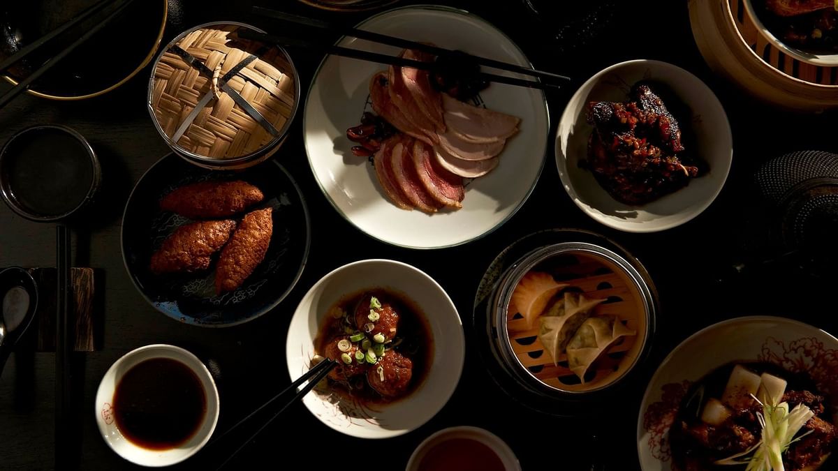 Chinese dishes on a dark table illuminated with natural light in Spice Temple at Crown Hotel Melbourne