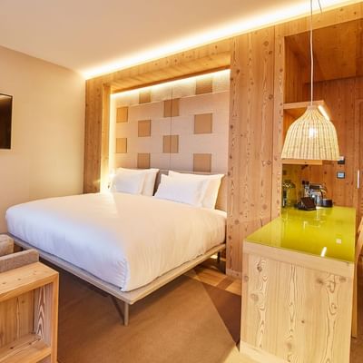 Junior Suite, Bed & lounge at Falkensteiner Hotel Kronplatz