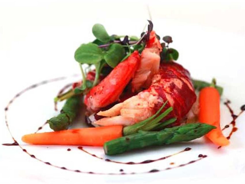 Lobster tail meat with asparagus, carrots, and a balsamic reduction drizzle served in Tudors Restaurant at Marygreen Manor