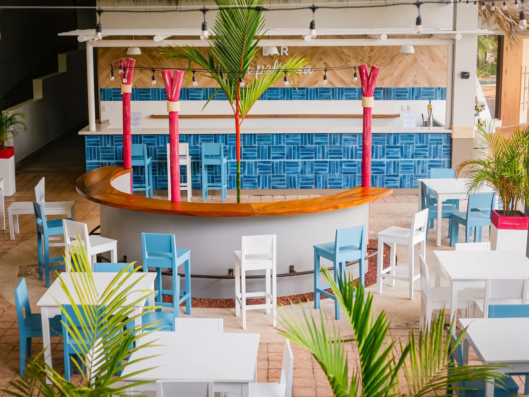 Colorful interior view of La Palmera Bar with arranged tables at Fiesta Resort