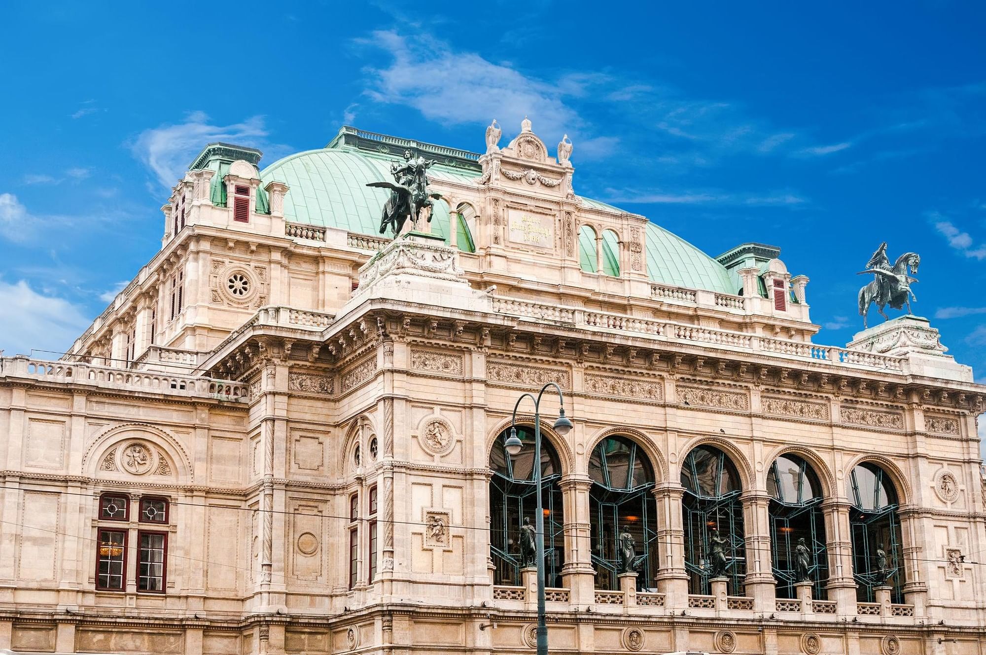 Wiener Staatsoper am Opernring mit historischer Fassade und grüner Kupferkuppel im Herzen von Wien.