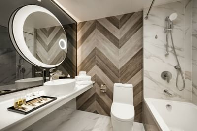Bathroom with a marble interior in Premier Family Quadruple Room at Park Hotel Hong Kong