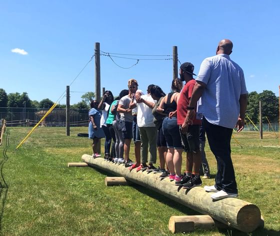 People balancing on a log near Honor’s Haven Retreat