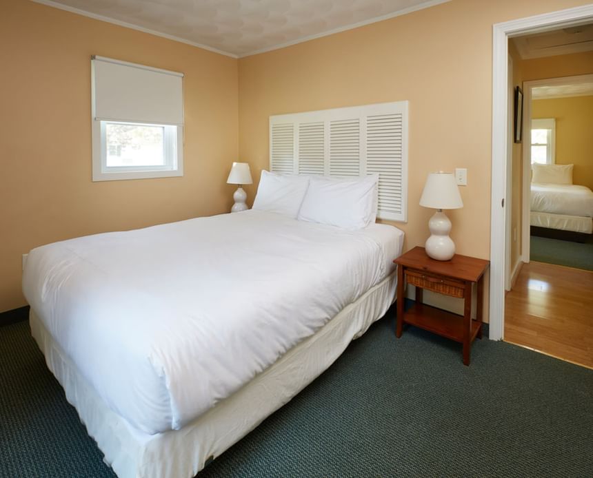 Neatly made bed by the window in Nick Cottage at Breezeway Boutique Hotel