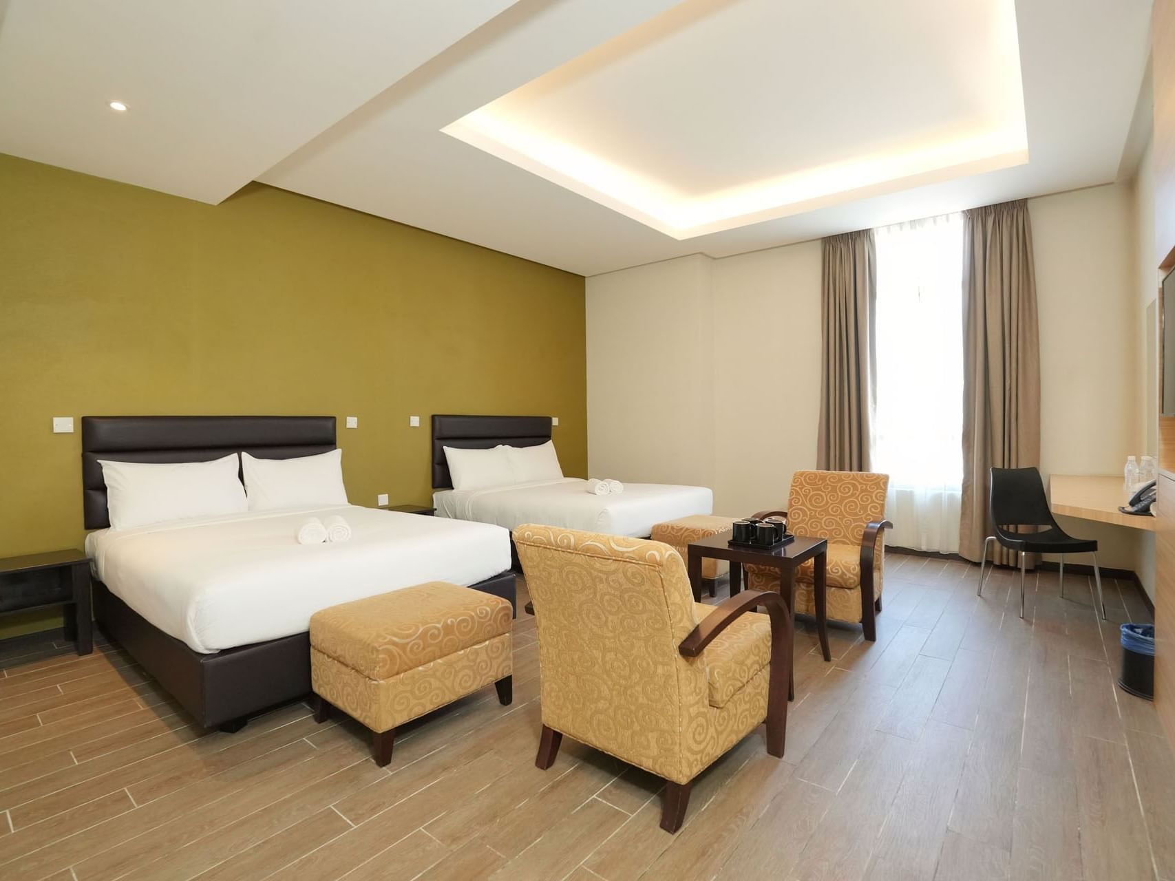 Lounge area by the beds in Executive Quad with wooden floors at Cititel Express Ipoh