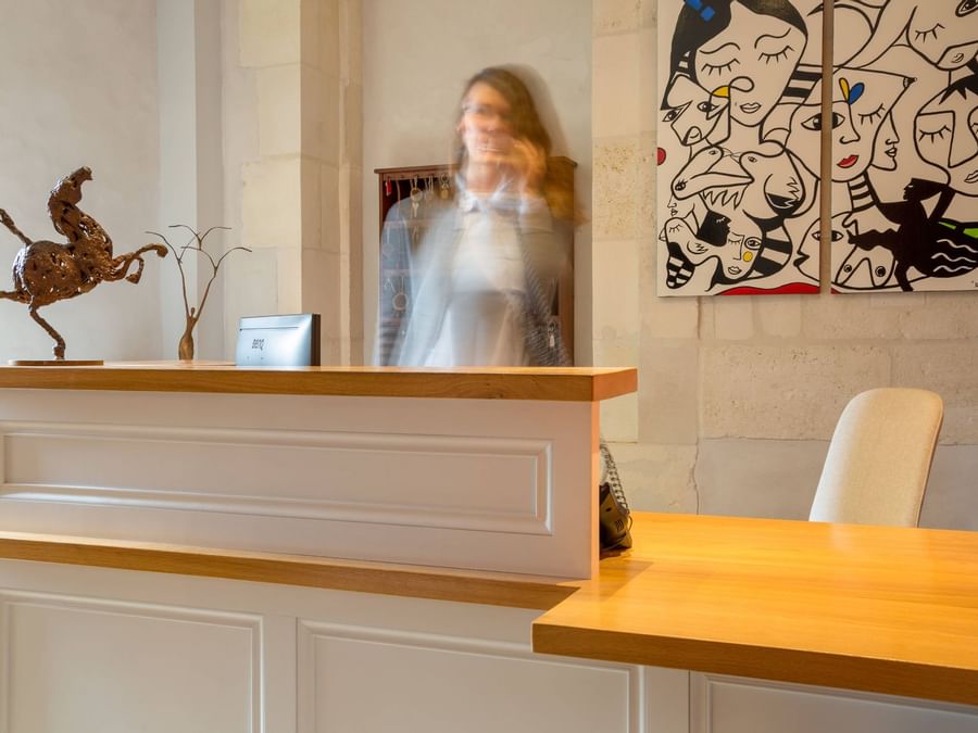 A receptionist at the reception desk in Residence de Rohan
