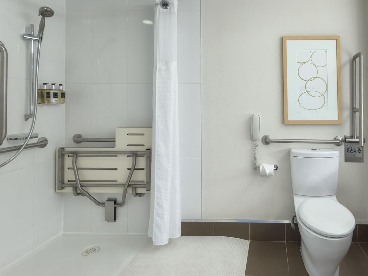 Clean accessible bathroom with shower and toilet at Coast Bastion Hotel in Nanaimo.