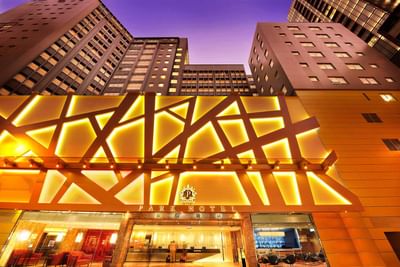 Low angle exterior view of Park Hotel Hong Kong with lit lights at night