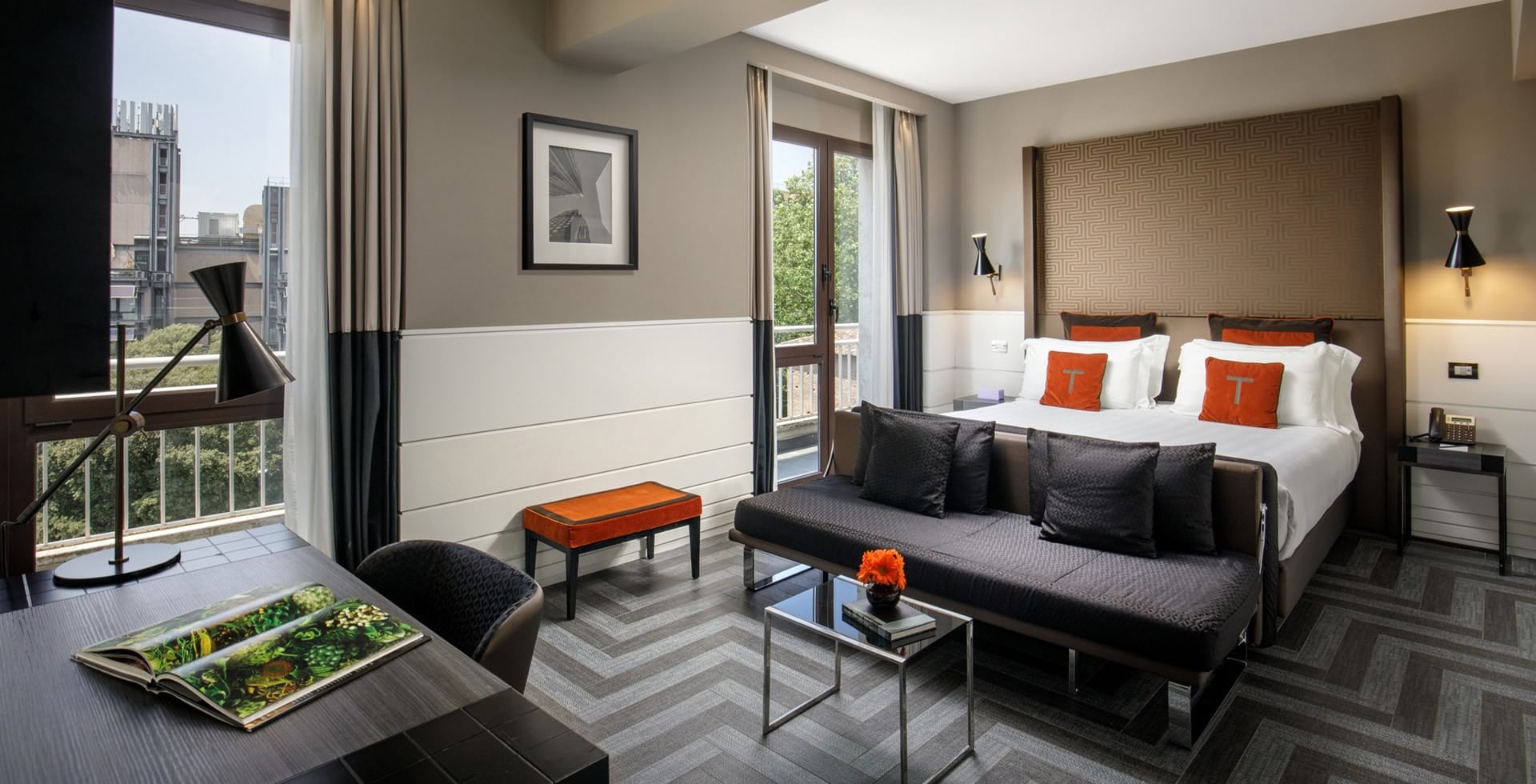 Spacious King Junior Suite at Tribune Hotel Rome with modern design, king bed, sofa lounge area, elegant décor, and balcony views of the city.