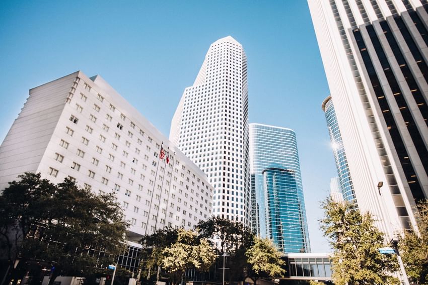 Skyline near The Whitehall Houston, with modern glass skyscrapers under a clear blue sky