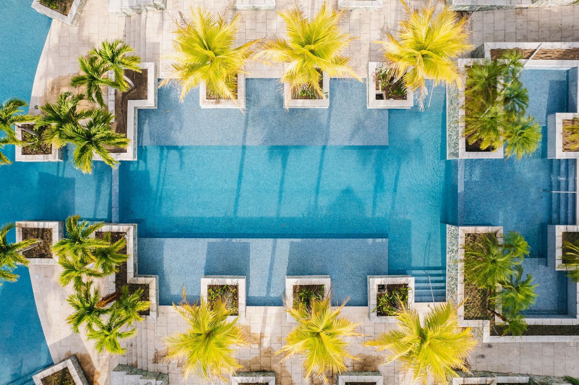 Aerial view of outdoor pool with palm trees at Indura Beach & Golf Resort