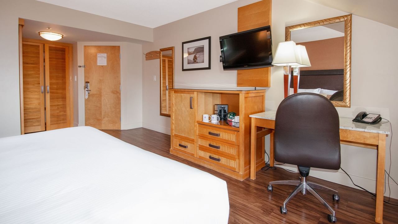 Hotel room with king bed, TV, work desk and window