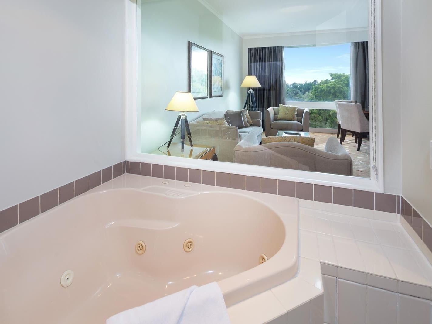 Bathtub with next to the living room with a beautiful view in Deluxe Spa Suite at Royal on the Park hotel