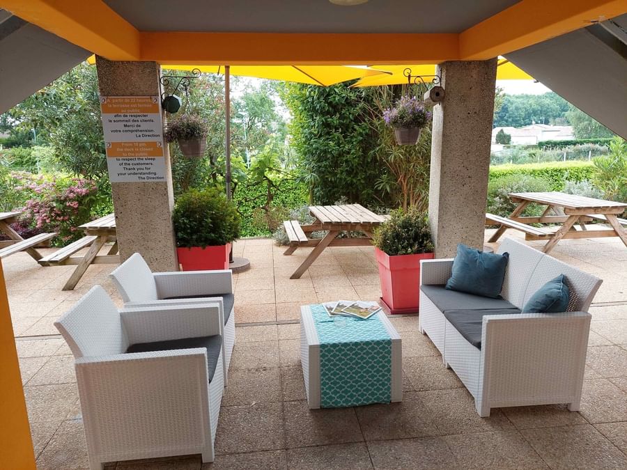 Outdoor lounge area with cozy seating at The Originals Hotels