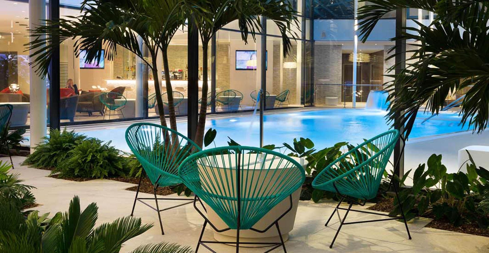 Outdoor pool with palm trees at Oceania Paris Roissy CDG