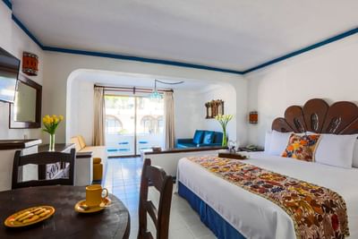 Suite luminosa con decoración mexicana, cama king, balcón y detalles artesanales en Los Arcos Suites