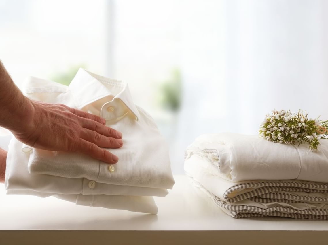 Man keeping folded clothes in the laundry at 3C Hotels